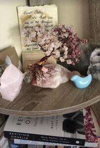 a setting of rose quartz and ceramic bird with a hadndmade wire and rose quartz tree in center